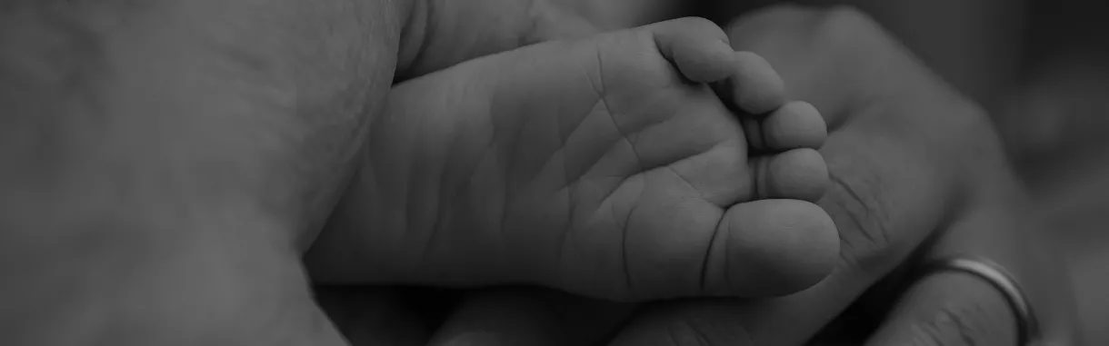 Baby foot held by parent hand